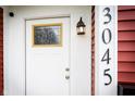 An up-close look at the front door with decorative window and exterior light fixture at 3045 N Lasalle St, Indianapolis, IN 46218