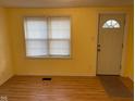Bright living room featuring wood flooring, a neutral color scheme, and a large window by the entry door at 318 Tague St, Greenfield, IN 46140