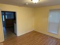 Inviting living room with laminate wood flooring, bright yellow walls, and natural light from a large window at 318 Tague St, Greenfield, IN 46140