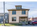Charming two-story home featuring a dormer window and light yellow siding and green trim accents at 425 E Walnut St, Indianapolis, IN 46202
