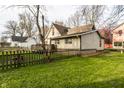The backyard features a well-maintained lawn, a wooden fence, and a small deck at 4610 W 72Nd St, Indianapolis, IN 46268