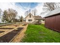 The backyard features raised garden beds, a lawn, a deck, and a fenced yard at 4610 W 72Nd St, Indianapolis, IN 46268