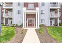 Inviting condo building entrance with decorative landscaping and a well-lit walkway at 6231 Amber Creek Ln # 312, Indianapolis, IN 46237