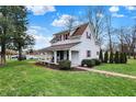 Two-story home with red shutters, a covered front porch, a well-manicured lawn, and tasteful landscaping at 6611 Valley Mills Ave, Indianapolis, IN 46241