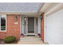 Close up of well maintained red brick house showcasing the front door with black sconces at 6628 Moss Cir, Indianapolis, IN 46237