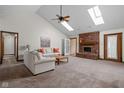 Spacious living room with vaulted ceilings, skylights, a brick fireplace, and neutral decor at 6628 Moss Cir, Indianapolis, IN 46237