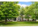 Charming two-story home with a well-manicured lawn and beautiful, mature trees at 7383 Poppyseed Dr, Indianapolis, IN 46237