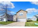 Charming two-story home with a well-maintained lawn, a garage and a pink front door with wreath at 8110 Crackling Ln, Indianapolis, IN 46259