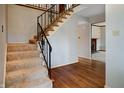 Inviting foyer featuring a staircase with decorative wrought iron railing and hardwood floors at 8151 Taunton Rd, Indianapolis, IN 46260