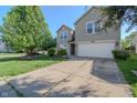 Charming two-story home with manicured landscaping, and a spacious driveway leading to an attached garage at 10309 Buckshire Ln, Indianapolis, IN 46234