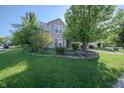 View of the front lawn, beautiful landscaping, and a two-story home in a peaceful neighborhood at 10309 Buckshire Ln, Indianapolis, IN 46234