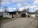 Charming home with a covered front porch and a detached garage, featuring a well-maintained lawn and gravel driveway at 127 Brunswick Dr, Greenwood, IN 46143