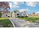 Traditional home with a spacious front yard, mature trees, and a detached garage at 1617 S N St, Elwood, IN 46036