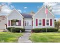 Quaint home featuring red shutters, neat landscaping, and an inviting walkway to the front door at 1617 S N St, Elwood, IN 46036