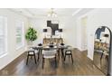 A beautifully staged dining room features modern furnishings, decor, and lighting, with hardwood floors at 18203 Sunbrook Way, Westfield, IN 46074