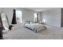 Sunlit bedroom with neutral carpet, light green bedding, and a full-length mirror at 2208 Gambel Ln, Danville, IN 46122
