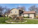 Attractive split-level home with stone and siding, complemented by landscaped flower beds in a verdant setting at 2605 Rollins Ct, Indianapolis, IN 46268