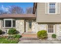 Inviting front entrance with decorative glass door, stone accents, and tiled steps, creating a warm welcome at 2605 Rollins Ct, Indianapolis, IN 46268