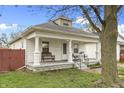 Charming home featuring a welcoming front porch with bench seating and a well-maintained lawn at 2709 S Mcclure St, Indianapolis, IN 46241