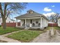 Charming home featuring a welcoming front porch with bench seating and a well-maintained lawn at 2709 S Mcclure St, Indianapolis, IN 46241