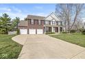Stunning view of a brick two-story home with a three-car garage and a long driveway at 3998 Jonathan Rdg, Columbus, IN 47201