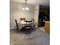 Cozy dining area with a round table, wooden chairs, and soft gray carpet at 4480 Village Ln # 2, Indianapolis, IN 46254