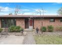 Brick home featuring a brick walkway, small garden, and red front door at 4935 W Carriage Dr, New Palestine, IN 46163