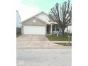 Charming single-story home with attached garage and well-maintained front yard and landscaping at 5437 Powder River Ct, Indianapolis, IN 46221