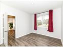 Bright bedroom with hardwood floors, natural light and neutral decor with red curtains at 5761 Handbell Ln, Greenwood, IN 46143