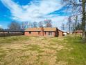 Spacious backyard with mature trees and a well-maintained lawn, perfect for outdoor activities at 619 Heritage Ln, Anderson, IN 46013