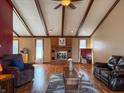 Cozy living room with exposed beam ceiling, brick fireplace, and hardwood flooring at 619 Heritage Ln, Anderson, IN 46013