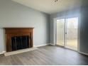 Spacious living room featuring laminate flooring, a fireplace, and a sliding glass door at 6640 Manassas Dr, Indianapolis, IN 46241