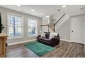 Cozy living room with wood laminate flooring, light gray walls, and ample natural light at 8613 N Meridian St, Indianapolis, IN 46260