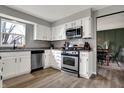 Updated kitchen with white cabinets, stainless steel appliances, and a view to the dining area at 8623 Appleby Ln, Indianapolis, IN 46256