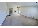 Bright living room featuring neutral carpeting, ceiling fan, and open view to the kitchen at 934 Sorrell Ct, Lebanon, IN 46052