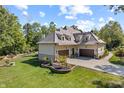 Aerial view of home, showcasing expansive backyard, three-car garage, and lush surroundings at 10821 Club Point Dr, Fishers, IN 46037