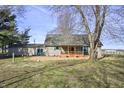 Backyard featuring a cozy, covered porch with an orange railing and an expansive lawn at 11686 S 825 W, Edinburgh, IN 46124