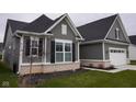Side angle of a beautiful home showcasing gray siding, white trim, and a well-maintained lawn at 1274 Clairet, Westfield, IN 46074