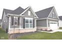Side view of gray home with brick detail, green lawn and an attached two-car garage at 1274 Clairet, Westfield, IN 46074