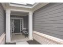 Covered front porch with gray siding, white trim, and a cozy seating area at 1274 Clairet, Westfield, IN 46074