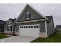 Attached two-car garage with gray siding and white trim, enhancing the curb appeal of the home at 1274 Clairet, Westfield, IN 46074