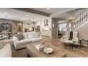 Open-concept living room with hardwood floors that seamlessly flows into a modern kitchen at 12889 Copper Run Blvd, Carmel, IN 46074