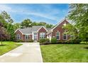 Beautiful brick home with a well-maintained lawn, complemented by lush trees and landscaping at 1361 Colinbrook Ct, Greenwood, IN 46143