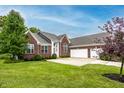 Attractive brick home with attached garage, green lawn, and mature landscaping at 1361 Colinbrook Ct, Greenwood, IN 46143