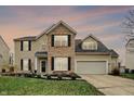 Charming two-story home featuring a blend of vinyl siding and brick accents, complemented by a well-manicured lawn at 14534 Baldwin Ln, Carmel, IN 46032