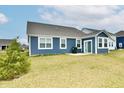 View of the rear exterior with blue siding and a sliding glass door to access the yard at 1803 Jackson St, Fortville, IN 46040