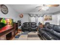 Cozy living room featuring comfortable leather seating, a ceiling fan, and a large television at 1847 Dutch Elm Dr, Indianapolis, IN 46231