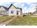 This home features vertical siding, cedar shake roof accent, and a compact front porch at 1854 Applegate St, Indianapolis, IN 46203
