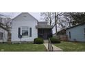 Charming home featuring a quaint screened-in front porch and tidy landscaping at 2028 George St, Anderson, IN 46016