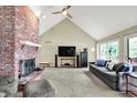 Bright living room featuring a vaulted ceiling, fireplace, and ample natural light through large windows at 22 Point Ln, Arcadia, IN 46030